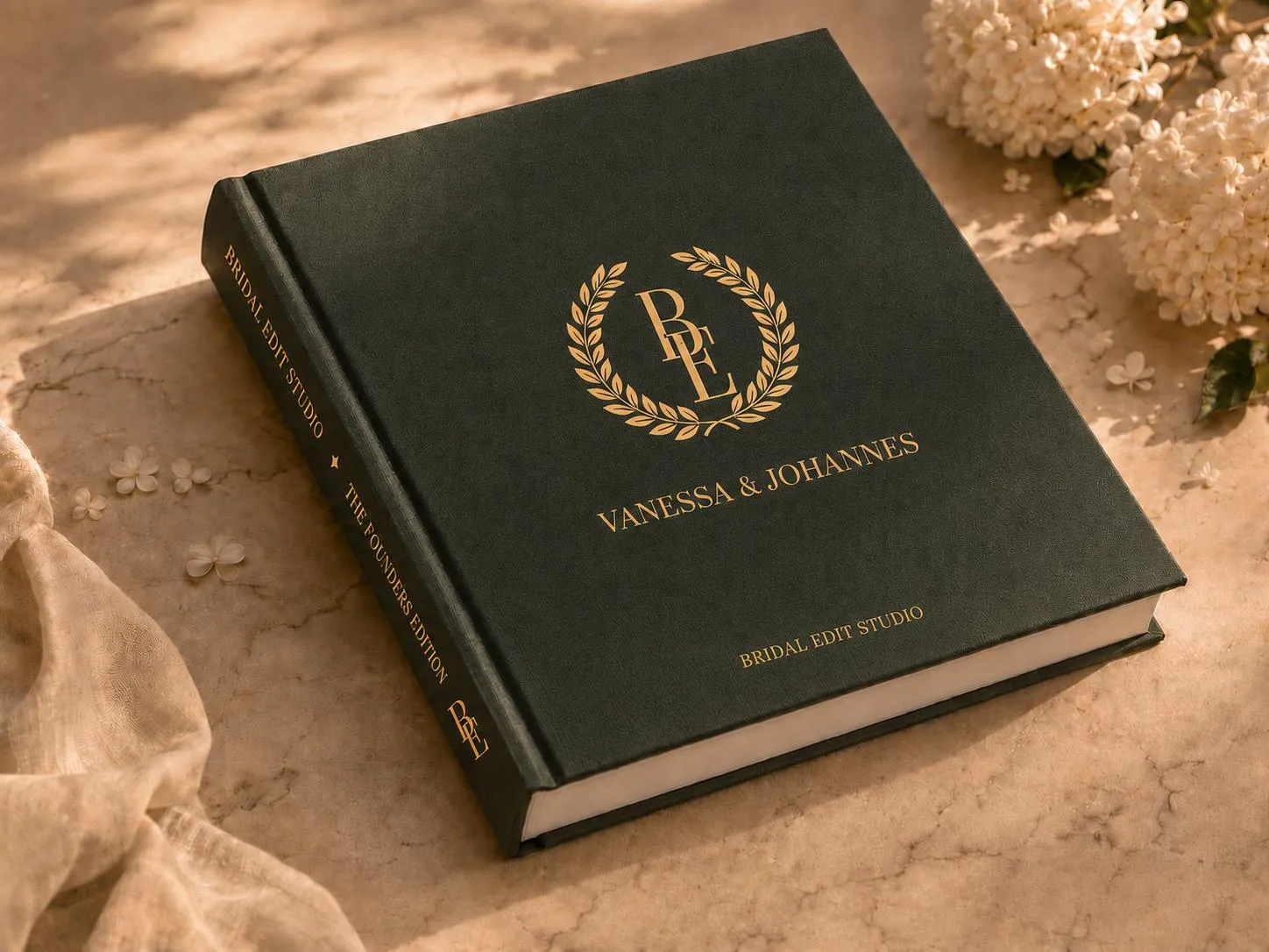 An open linen presentation box on stone: a deep green interior stamped “Heirloom Edition” in gold, a gold BE medallion in its recess and a green folio lettered “A Legacy for generations”